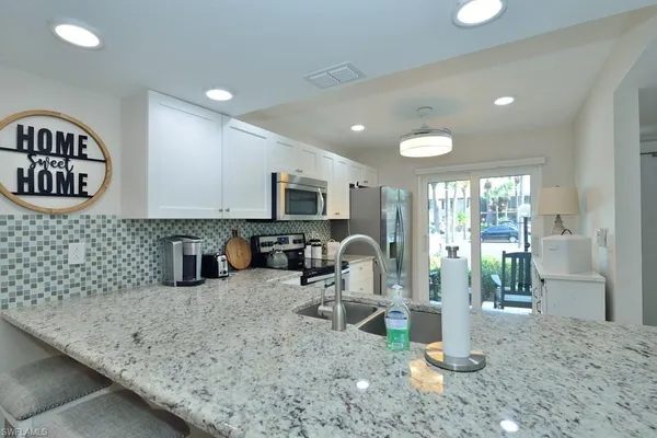 a kitchen with sink cabinets and glass door