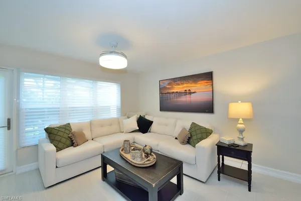 a living room with furniture a rug and a large window