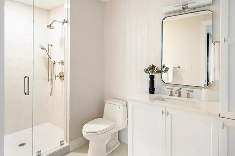 a bathroom with a granite countertop sink toilet and shower