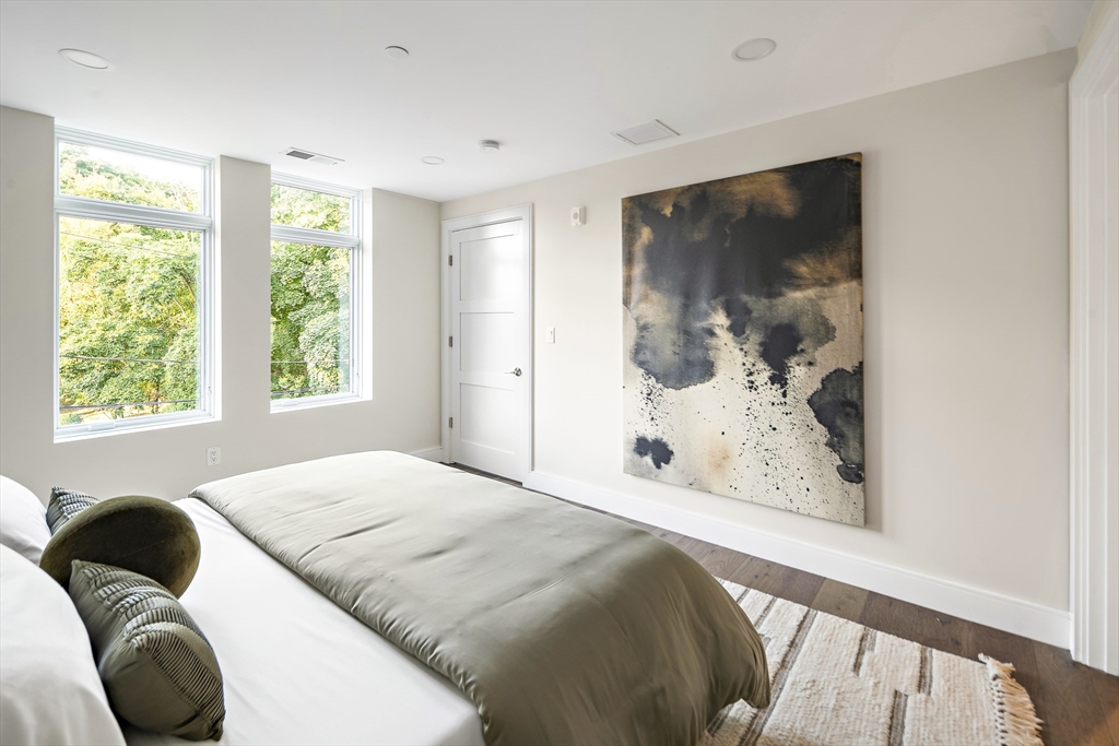 20 Kinmonth Road, Unit 301 Newton, MA 02468 - Photo 24 of 30 a bedroom with a bed and a painting on the wall