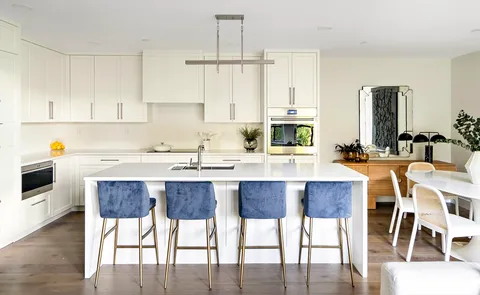 a kitchen with a dining table chairs and white cabinets