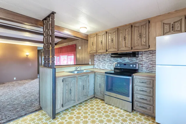 a kitchen with kitchen island granite countertop a refrigerator a sink and dishwasher