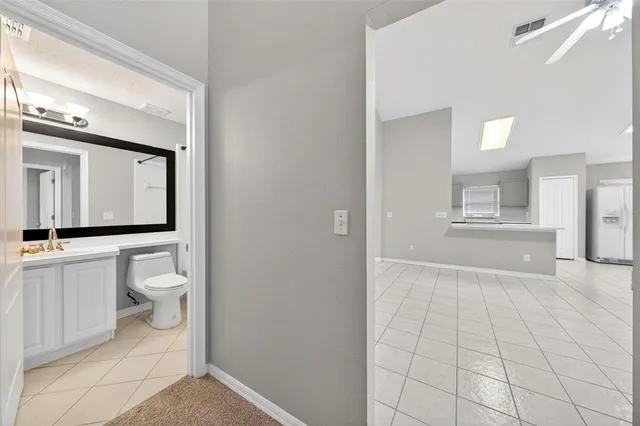 a bathroom with a toilet a sink a mirror a bathtub and vanity