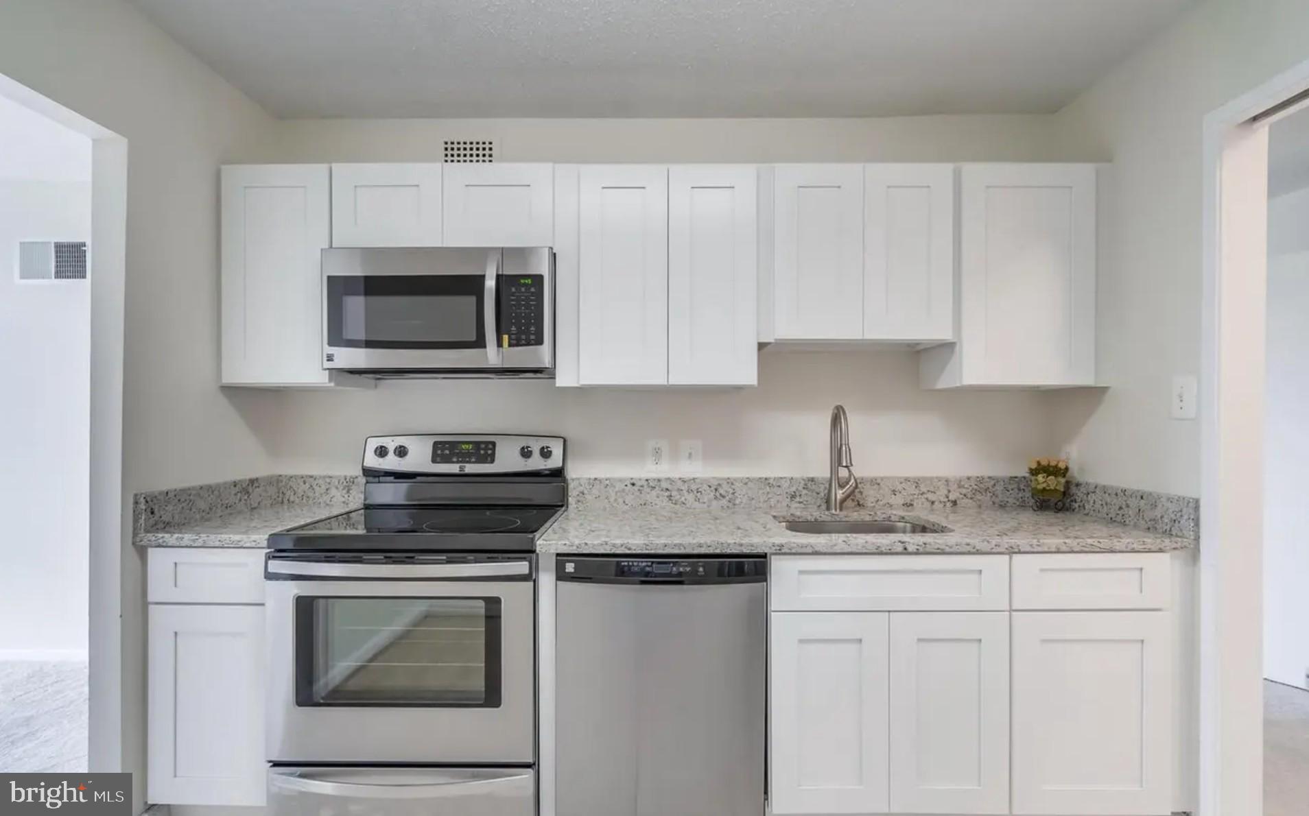 2311 Pimmit Drive, Unit 808 Falls Church, VA 22043 - Photo 7 of 24 a kitchen with granite countertop white cabinets and stainless steel appliances