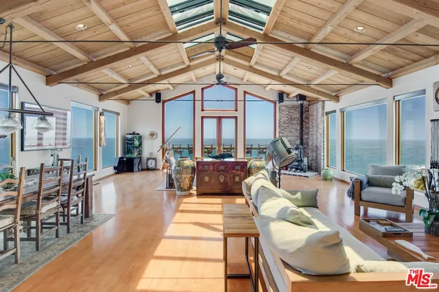 a living room with furniture a wooden floor and next to a window
