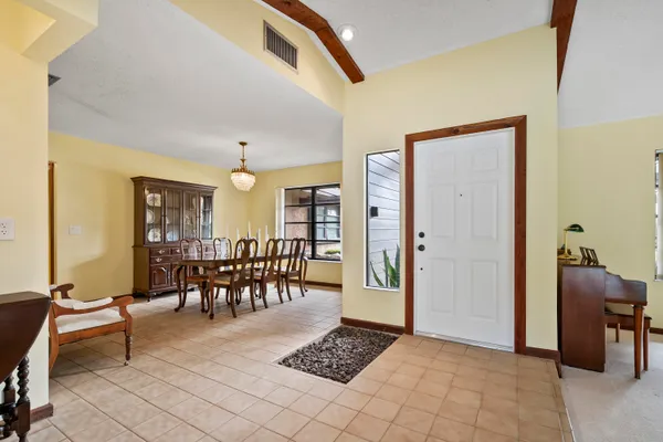 a living room with furniture a dining table and a potted plant
