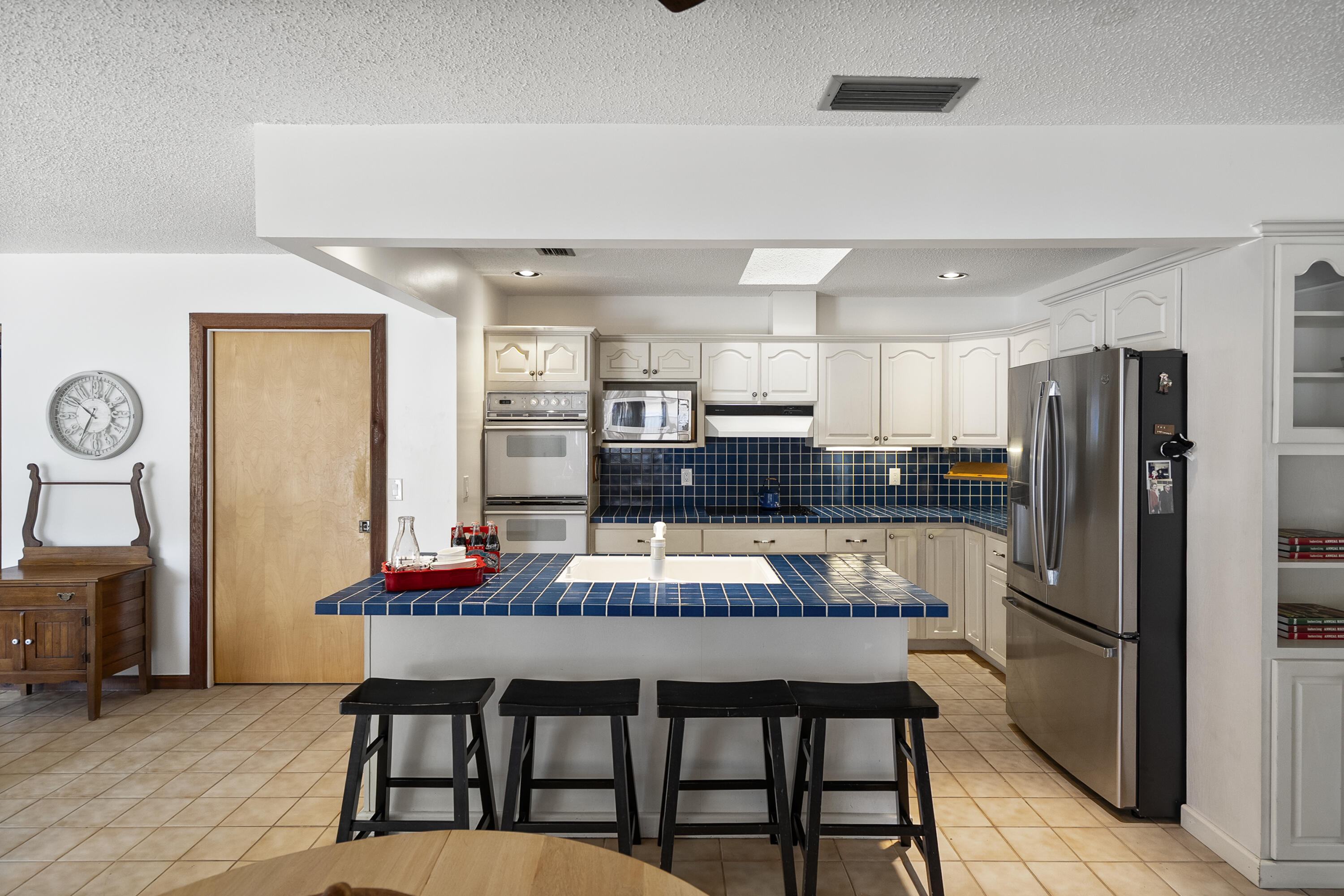 18815 South Golden Hawk Trail Jupiter, FL 33458 - Photo 17 of 49 a kitchen with stainless steel appliances granite countertop a refrigerator a stove top oven a dining table and chairs with wooden floor