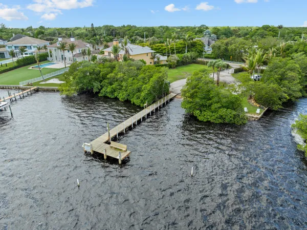 an aerial view of a house with a yard and lake view