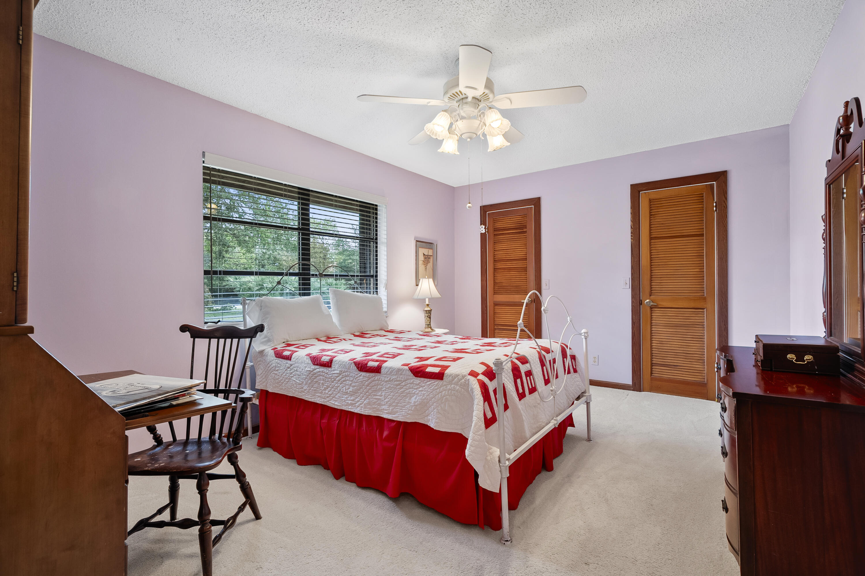 18815 South Golden Hawk Trail Jupiter, FL 33458 - Photo 32 of 49 a bedroom with a bed table chair and a window