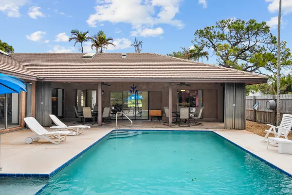 a view of a house with swimming pool and sitting area