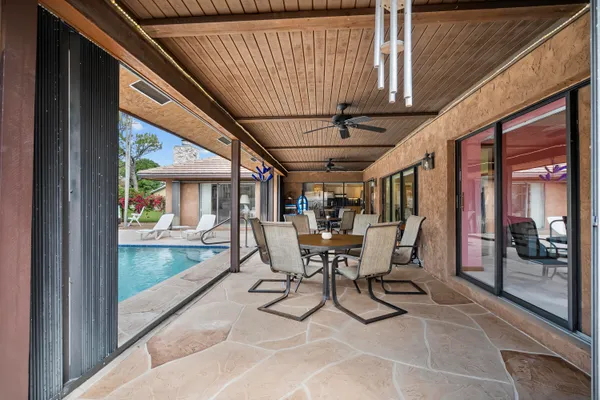a view of a patio with table and chairs and wooden floor