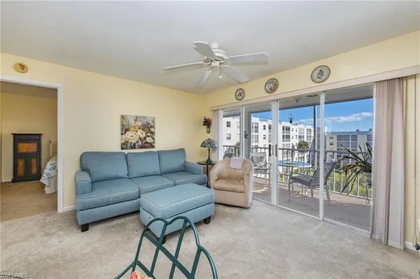 a living room with furniture and a ceiling fan