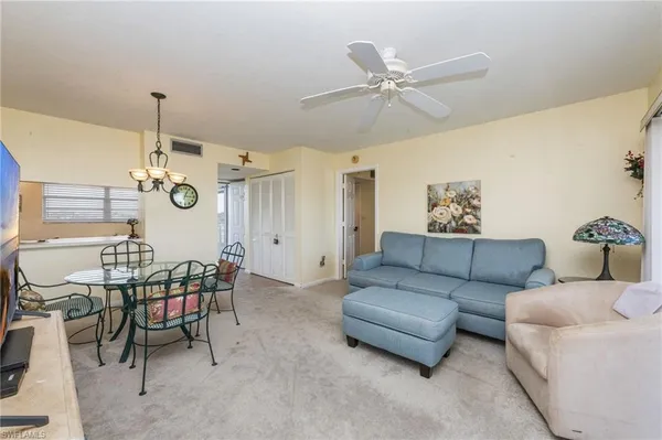 a living room with furniture a dining table and a chandelier