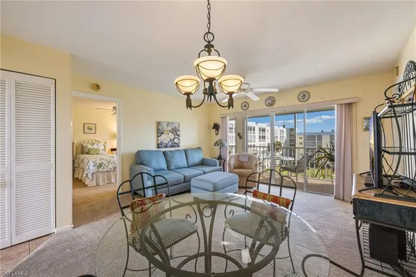 a view of a dining room with furniture a chandelier and large window