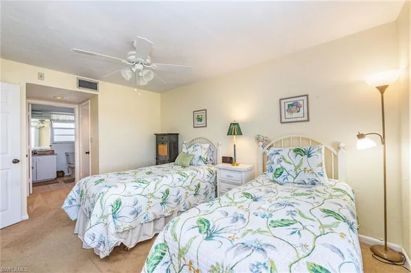 a bedroom with three beds and a chandelier