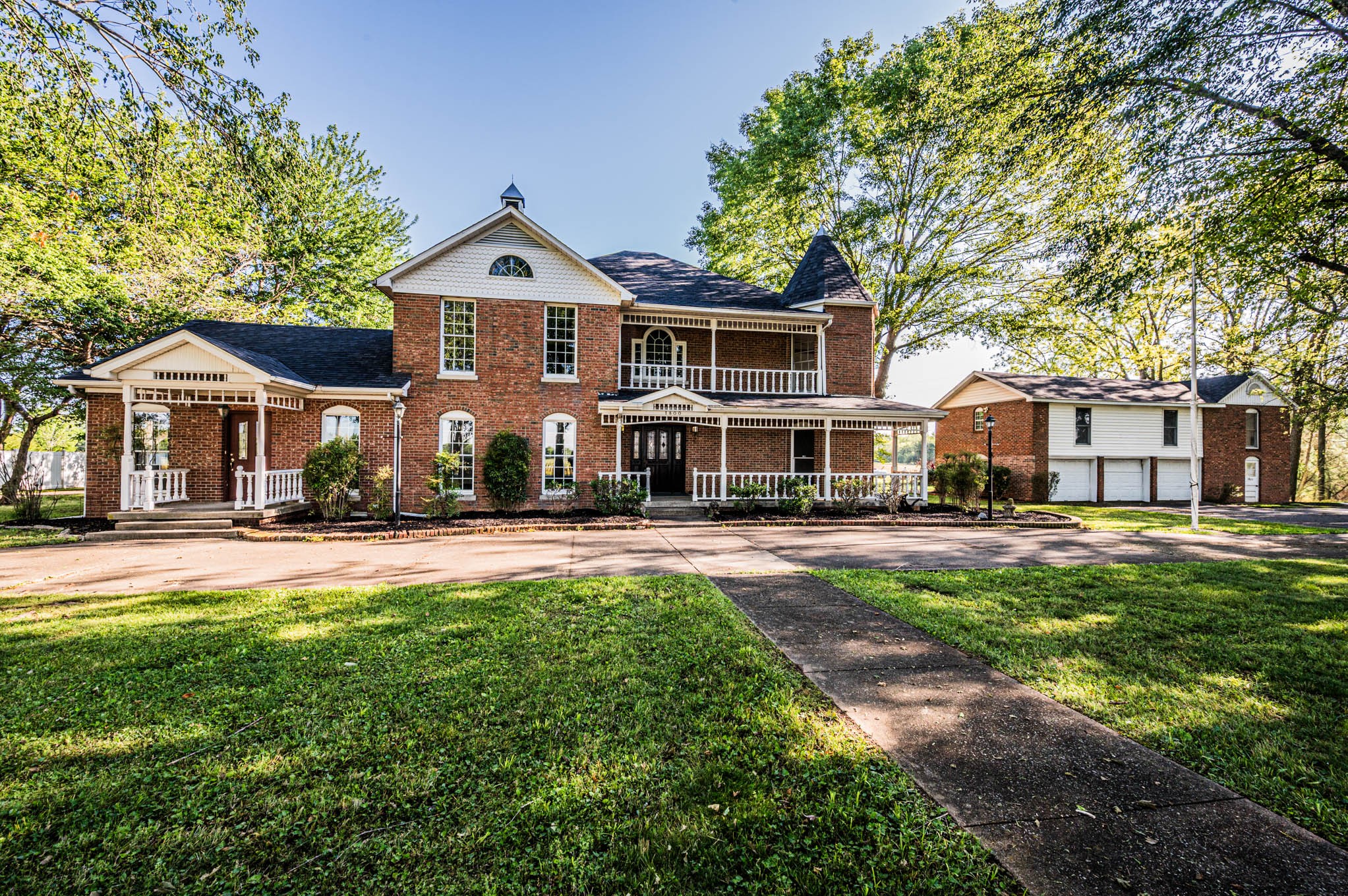 a front view of a house with a porch and garden
