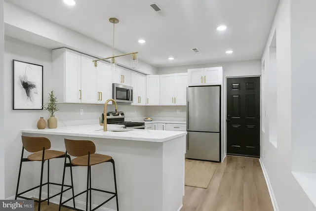 a kitchen with stainless steel appliances a refrigerator stove microwave and cabinets