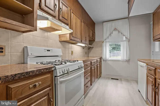 a kitchen with a stove and a wooden floor