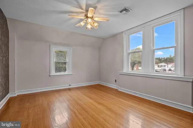a view of empty room with window and wooden floor