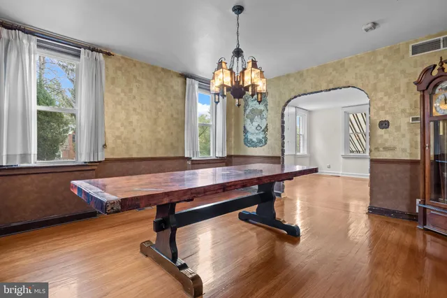 a room with wooden floor pool table and windows