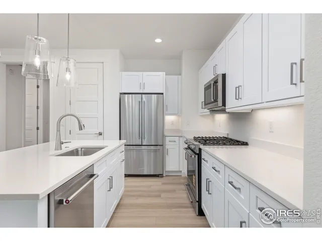 a kitchen with a sink a refrigerator a stove and cabinets