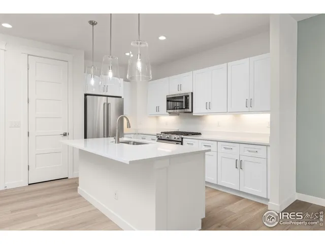 a kitchen with kitchen island granite countertop a sink cabinets and stainless steel appliances