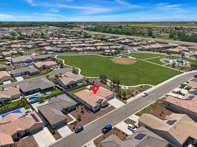 an aerial view of a city with lots of residential buildings and ocean view in back