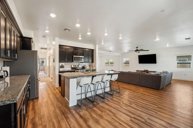 a large living room with stainless steel appliances kitchen island granite countertop a large counter top stainless steel appliances a couch and a view of living room