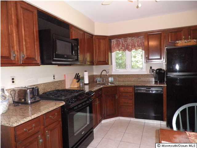 26 Turnberry Drive Lincroft, NJ 07738 - Photo 6 of 16 a kitchen with granite countertop a stove sink and microwave