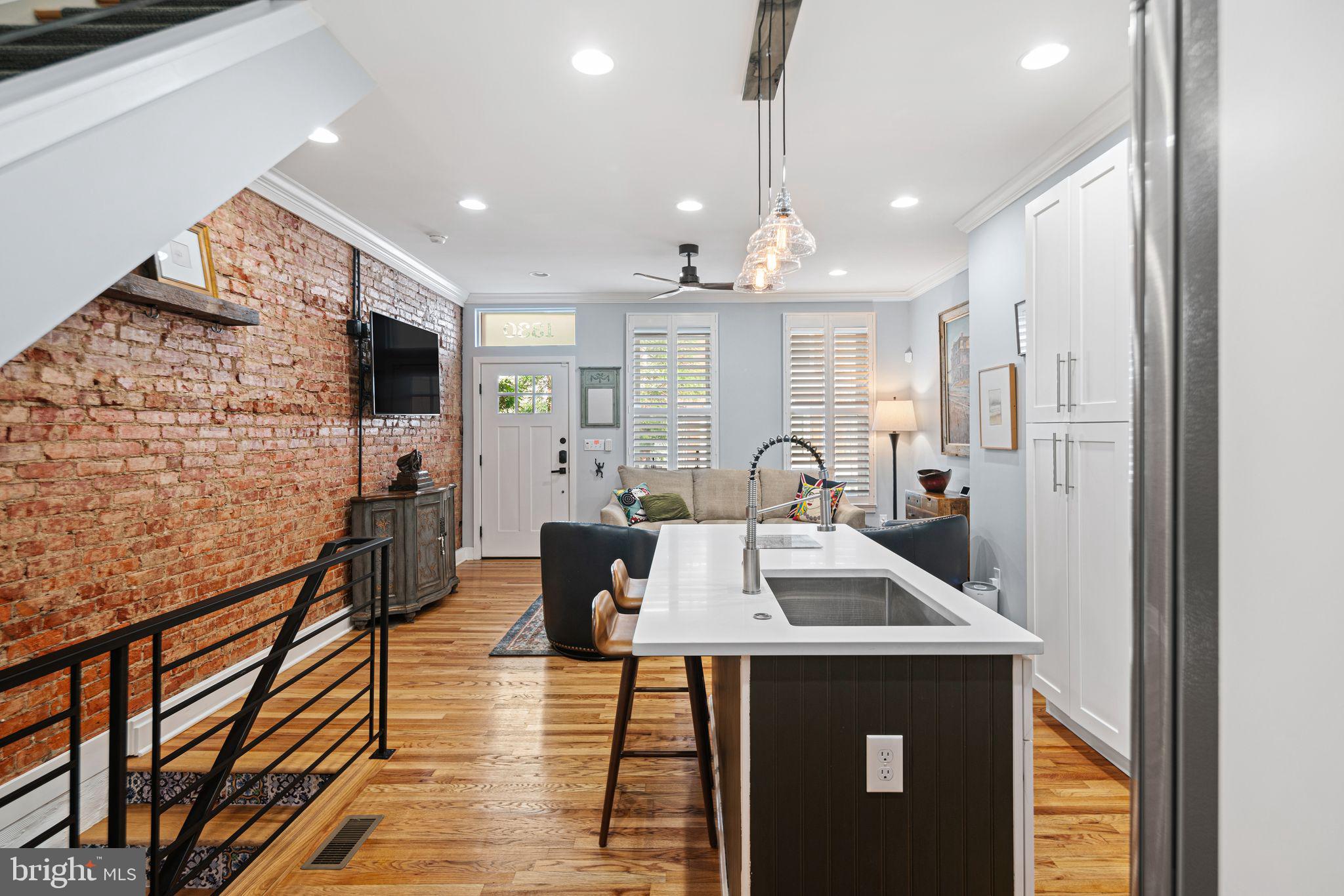 1330 South 16th Street Philadelphia, PA 19146 - Photo 4 of 37 a kitchen with stainless steel appliances kitchen island granite countertop a refrigerator a stove and a sink with wooden floor