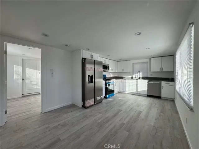 a kitchen with stainless steel appliances a refrigerator and wooden floor
