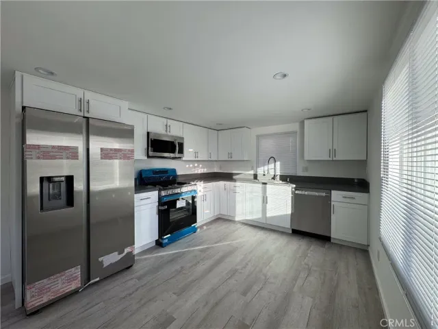 a kitchen with stainless steel appliances a stove sink and refrigerator