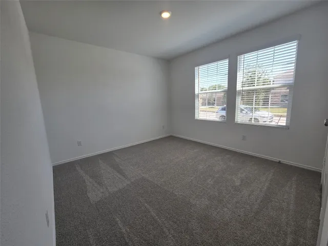 a large kitchen with stainless steel appliances granite countertop a stove a sink a refrigerator and white cabinets