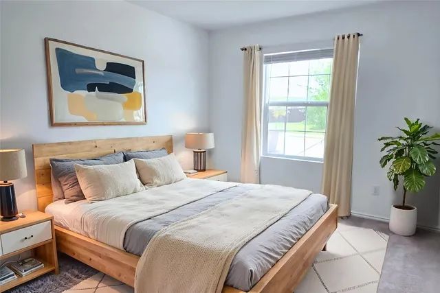 a bedroom with bed and a potted plant