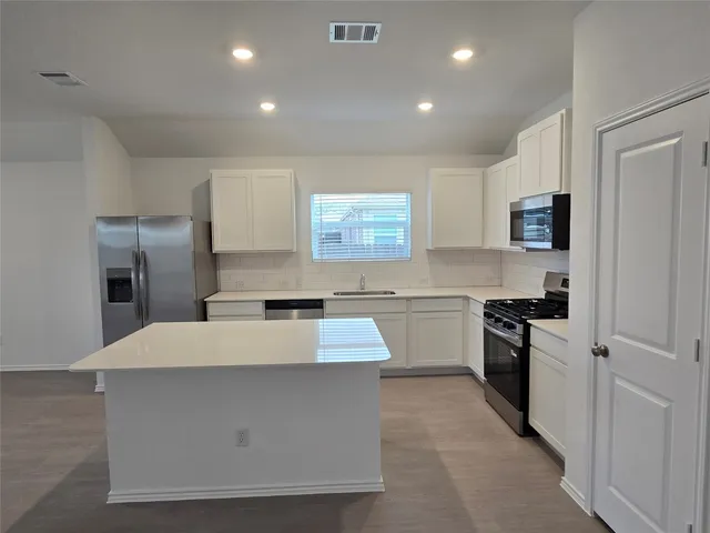 a large kitchen with stainless steel appliances