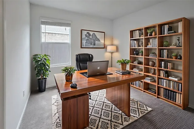 a view of a workspace with furniture and a bookshelf