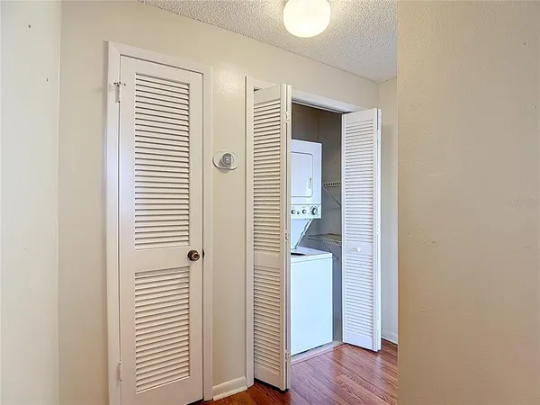 a view of a hallway with wooden floor and closet