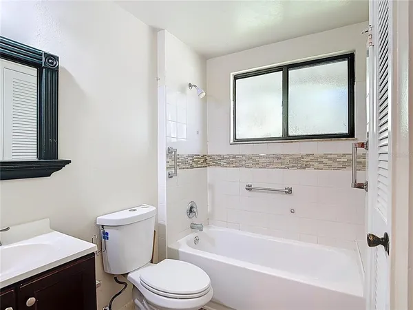 a bathroom with a granite countertop toilet sink and bathtub