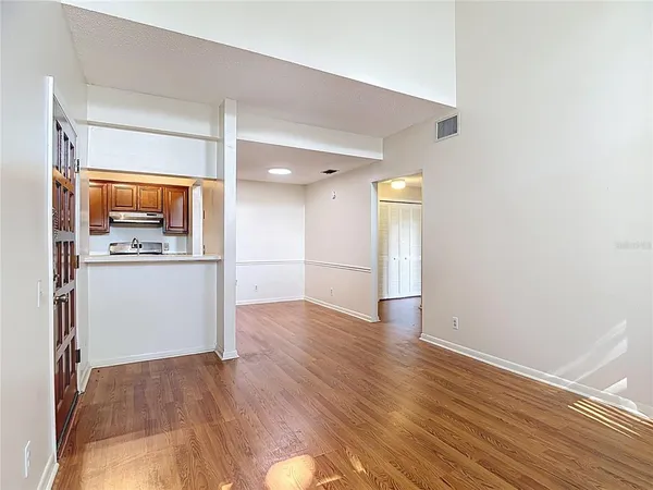 a view of a kitchen with a fridge and wooden floor