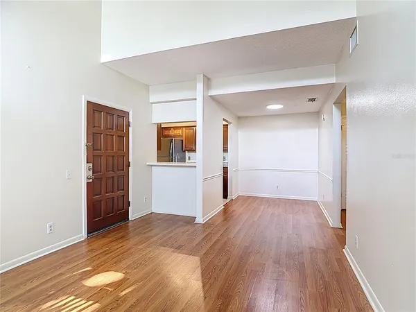 a view of a big room with wooden floor and windows