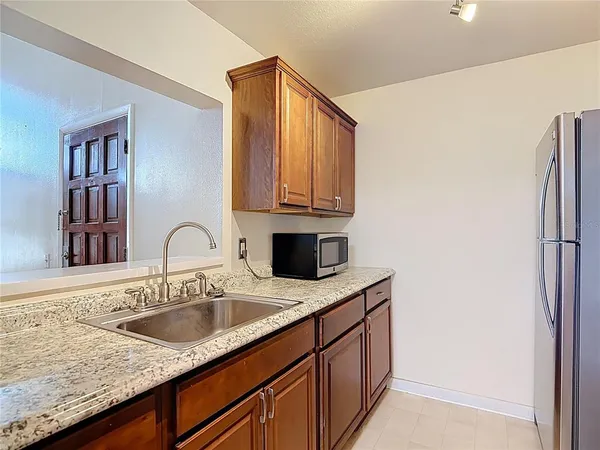 a kitchen with stainless steel appliances granite countertop a sink a refrigerator and cabinets
