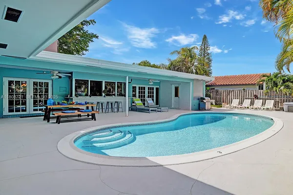 a view of a house with swimming pool and furniture