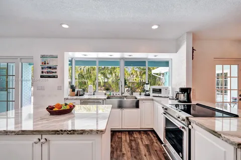 a kitchen with granite countertop a stove and a sink