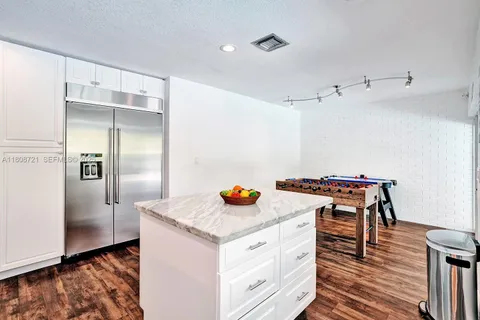 a kitchen with stainless steel appliances granite countertop a refrigerator and a stove