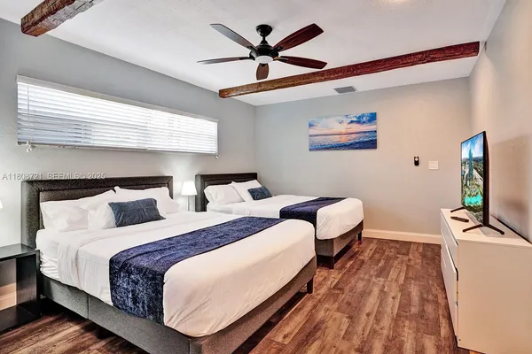 a bedroom with two bed and a flat screen tv