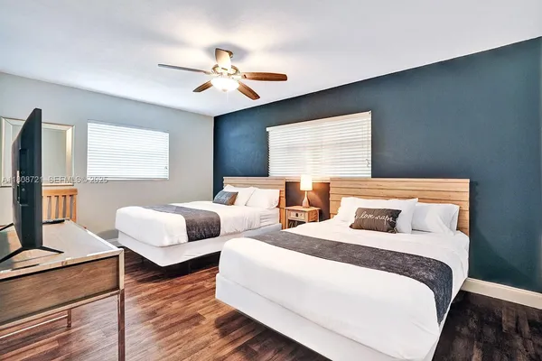 a bedroom with two beds and a chandelier