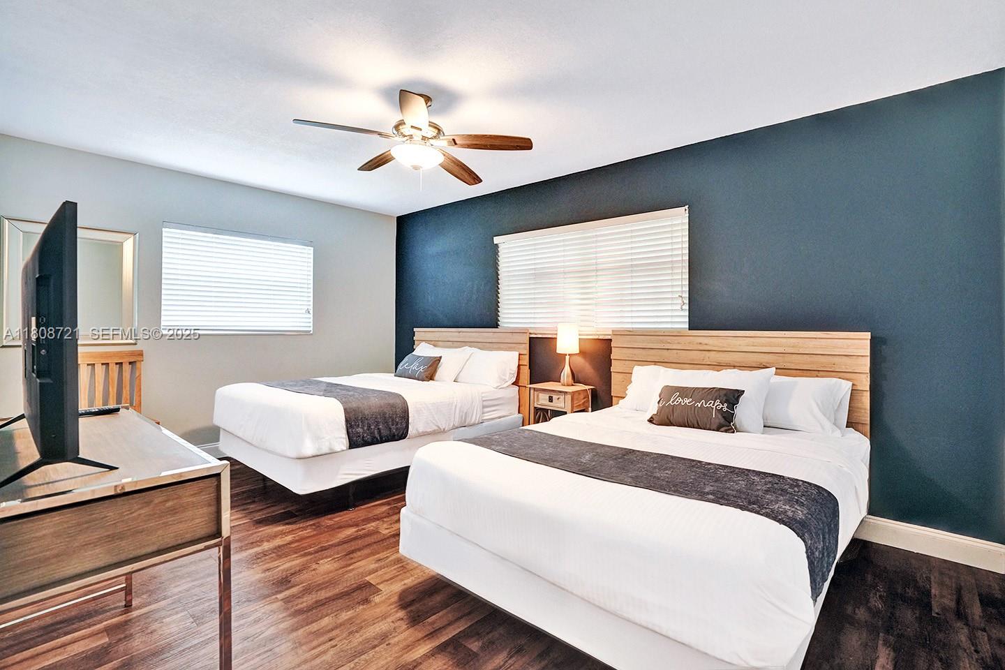 1245 Wiley Street Hollywood, FL 33019 - Photo 24 of 43 a bedroom with two beds and a chandelier