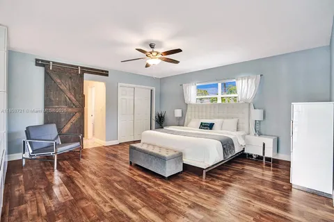 a spacious bedroom with a bed a chair and a large window