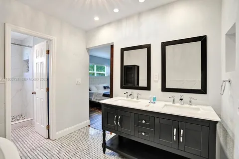 a bathroom with a double vanity sink a mirror and a shower