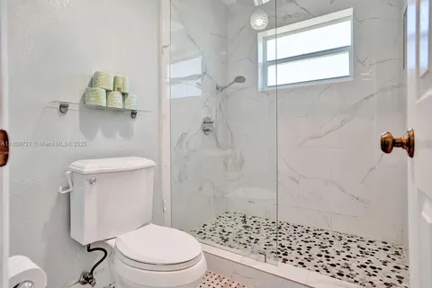 a bathroom with a toilet and a shower